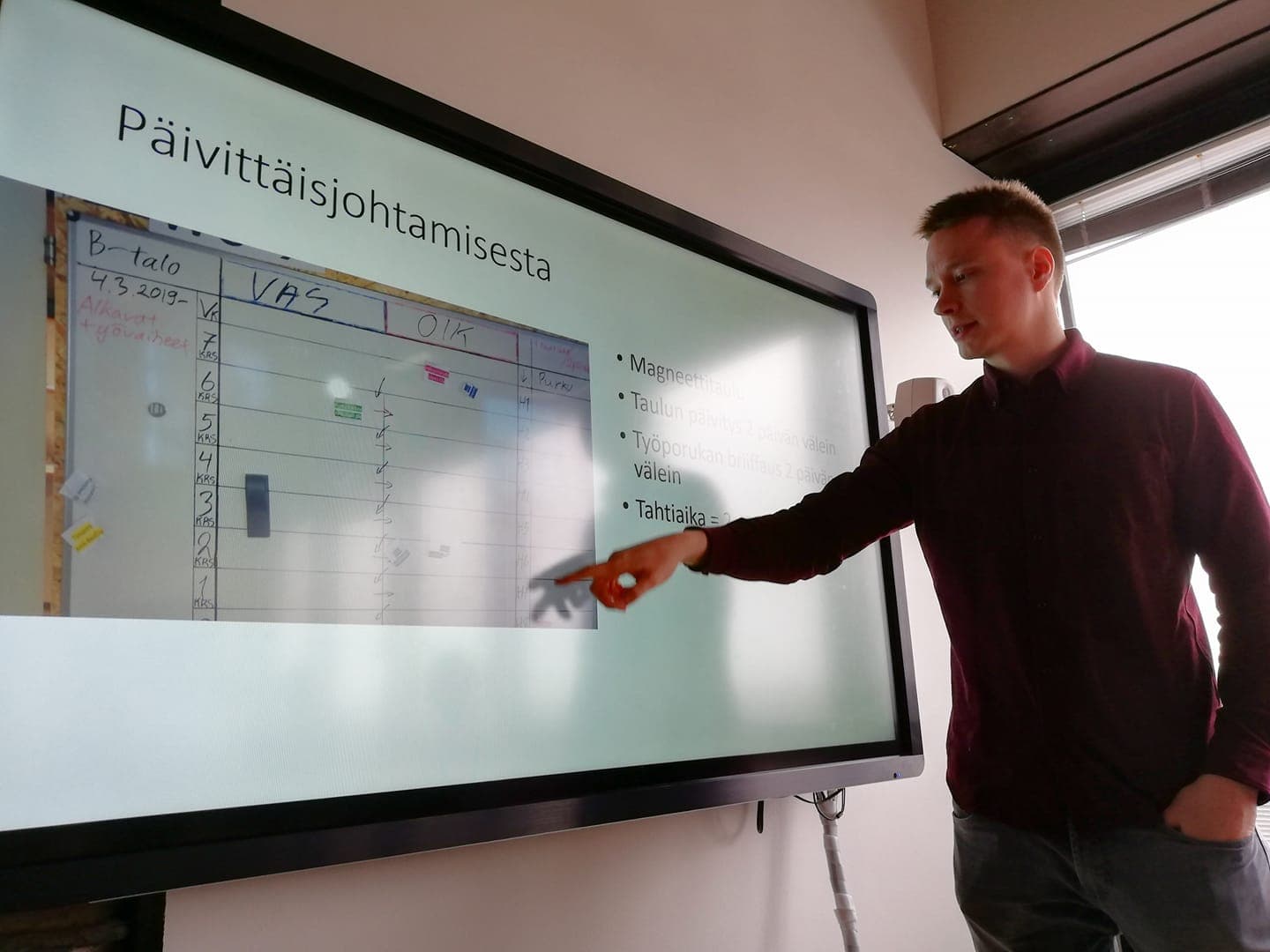 Kimmo Keskiniva esittelee päivittäisjohtamisen keinoja, tässä seinällä olevaa päivitettävää aikataulukaaviota. (kuva: Minna Kuusela)