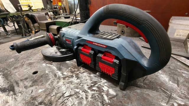 Kuvassa on Bosch Expert sarjan 230mm akkukulmahiomakone pöydällä metallipajassa.