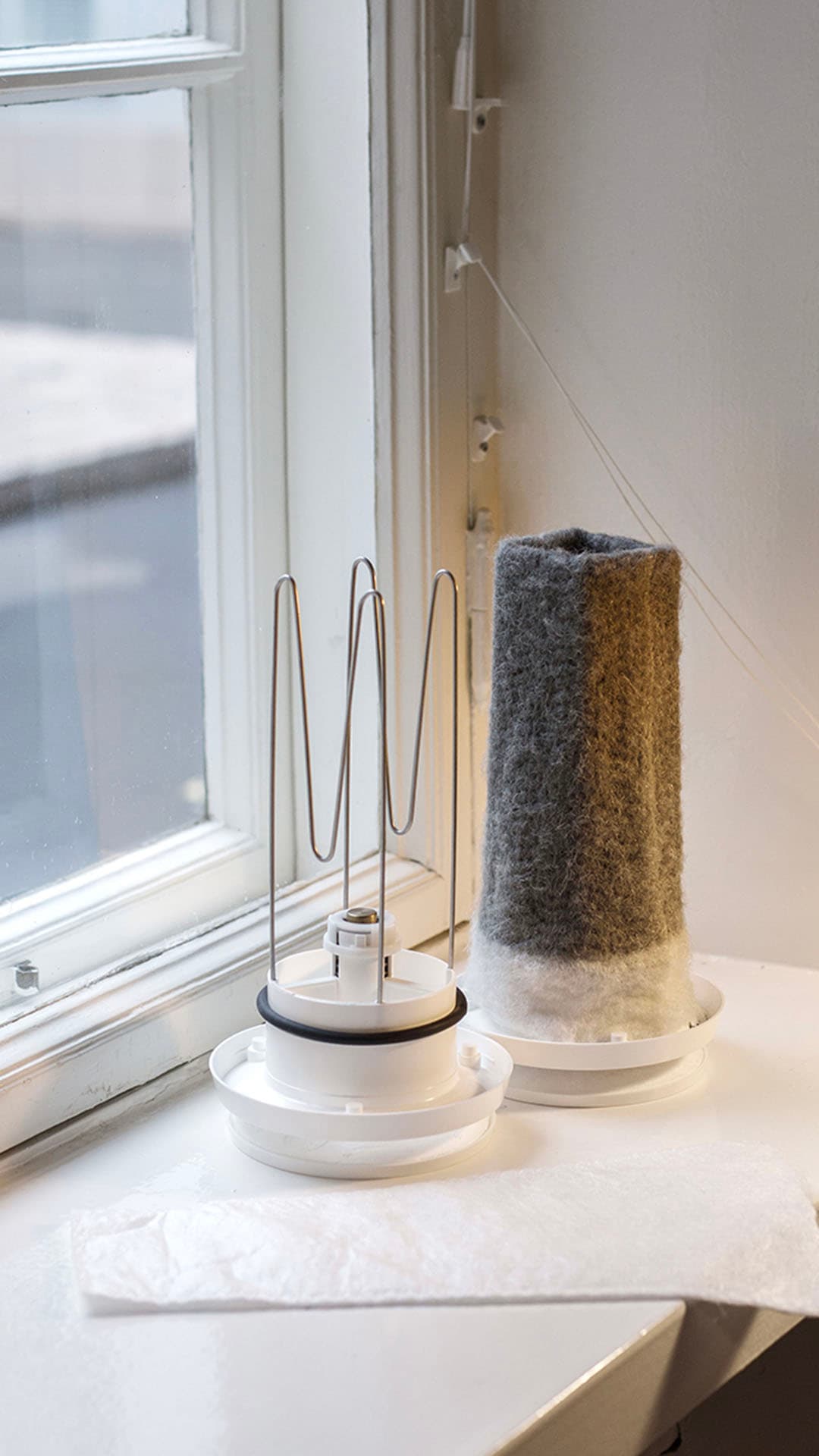 Puhdas ja likainen korvausilmaventtiilin suodatin ikkunalaudalla.