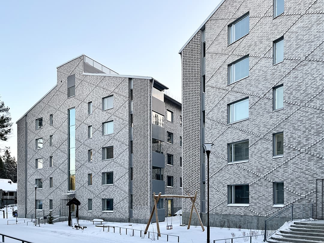 Vaalea tiilijulkisivu joka on kuvioitu muuraamalla