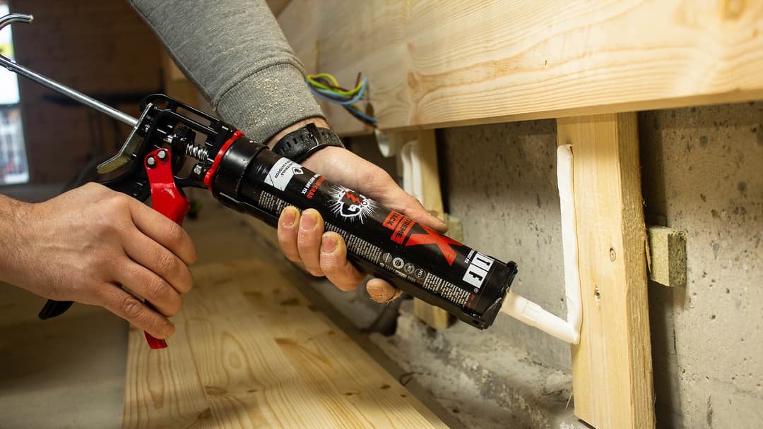 kuvassa rakennusmies puristaa liimaa koolauspuuhun ja aikoo liimata paneelin seinään wtf x liimalla