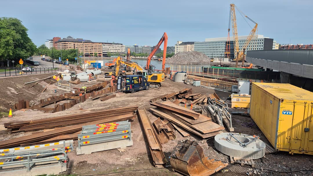 rakennustyömaa ulkona Helsingissä. Alueella rakennustarvikkeita ja työkoneita